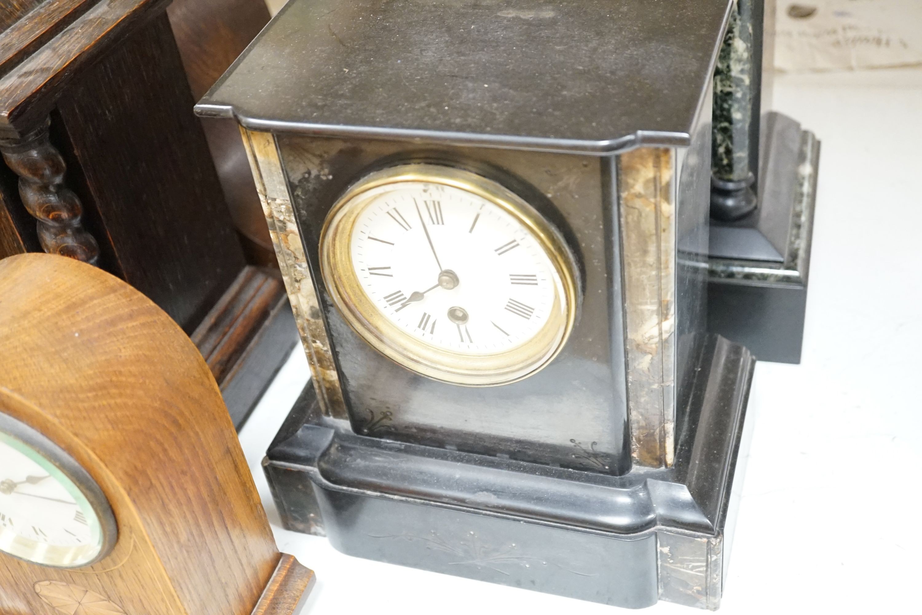 Two 19th century slate mantel clocks, three Edwardian and later wooden mantel clocks and a barometer, tallest 31 cms high.
